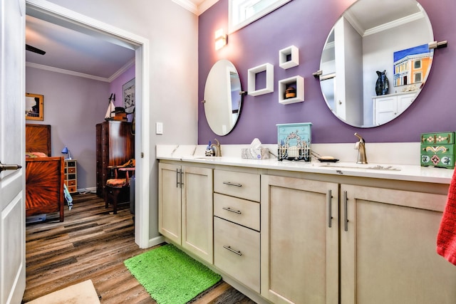 full bath with ornamental molding, double vanity, a sink, and wood finished floors