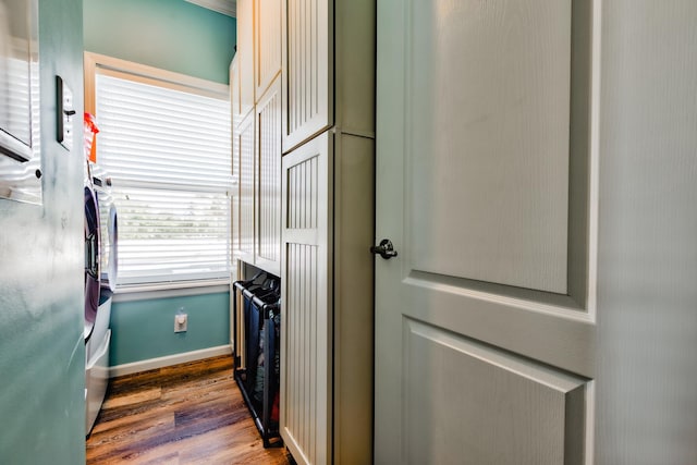 laundry room featuring wood finished floors, cabinet space, and baseboards