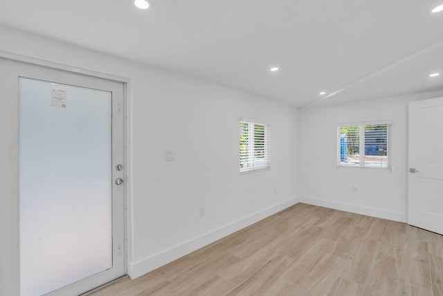 empty room with lofted ceiling and light hardwood / wood-style floors