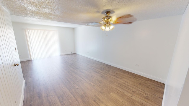 spare room featuring baseboards, a ceiling fan, and wood finished floors