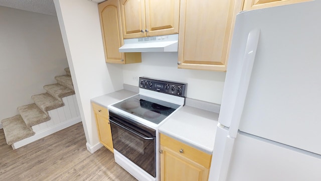 kitchen with white appliances, light brown cabinets, and under cabinet range hood