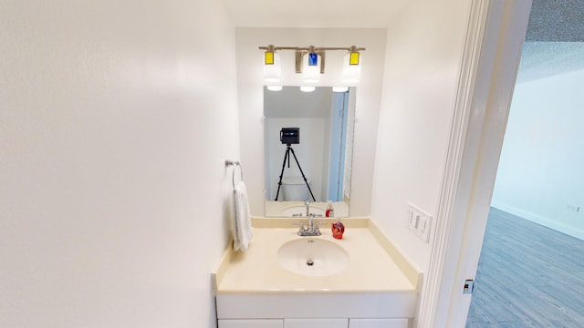 bathroom with wood finished floors and vanity