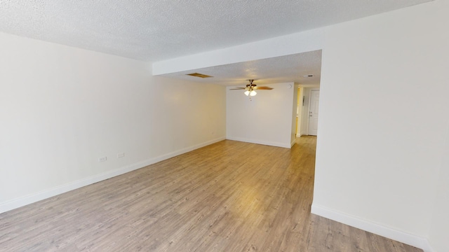 spare room with visible vents, baseboards, a ceiling fan, a textured ceiling, and light wood-type flooring