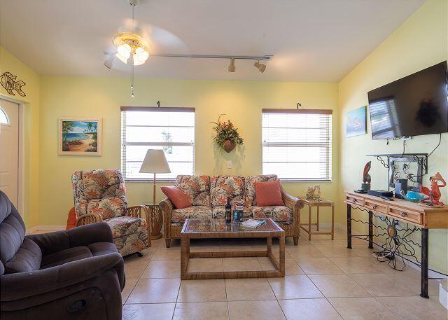 living room featuring a wealth of natural light, track lighting, ceiling fan, and light tile patterned flooring