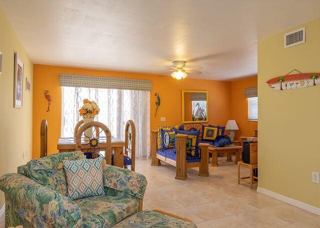 living room with ceiling fan, light tile patterned floors, and a healthy amount of sunlight