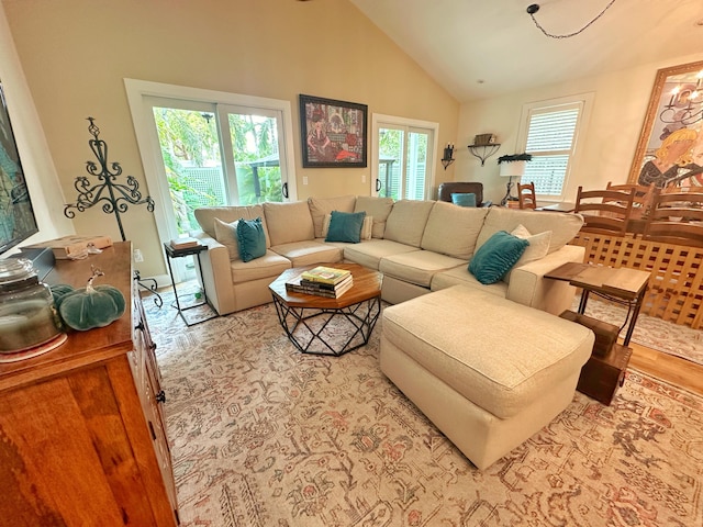 living room with high vaulted ceiling and light wood-type flooring