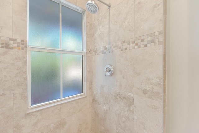 bathroom featuring plenty of natural light and tiled shower