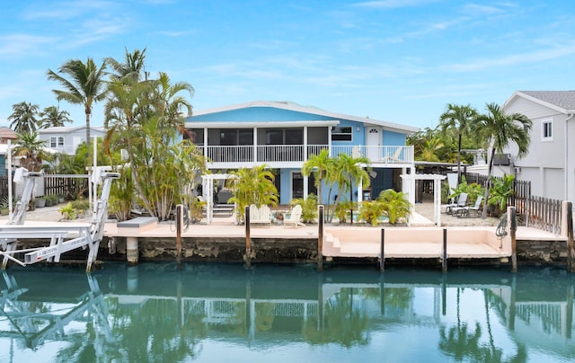 back of house with a water view, a patio area, and a sunroom