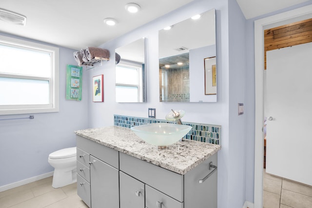 bathroom with vanity, plenty of natural light, tile patterned floors, and toilet