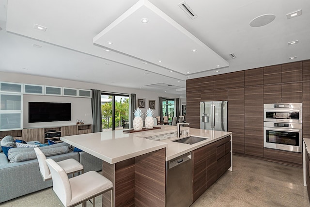 kitchen featuring stainless steel appliances, sink, a kitchen breakfast bar, and a large island