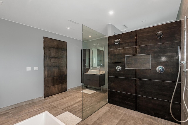 bathroom featuring a tile shower and vanity