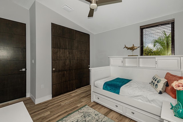 bedroom with hardwood / wood-style flooring, vaulted ceiling, and ceiling fan