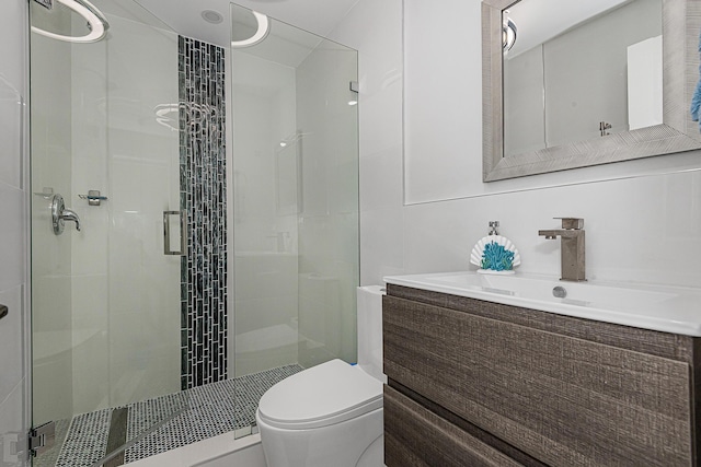 bathroom with vanity, a shower with shower door, and toilet