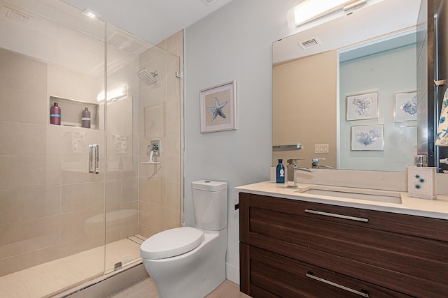 bathroom featuring vanity, toilet, and a shower with shower door