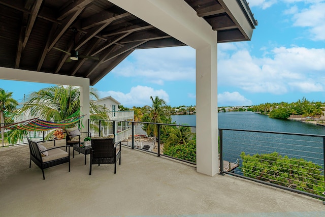 balcony featuring ceiling fan and a water view