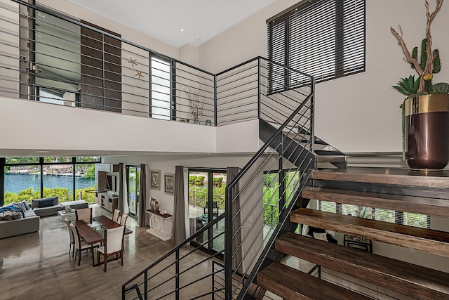 stairs with a towering ceiling and concrete floors