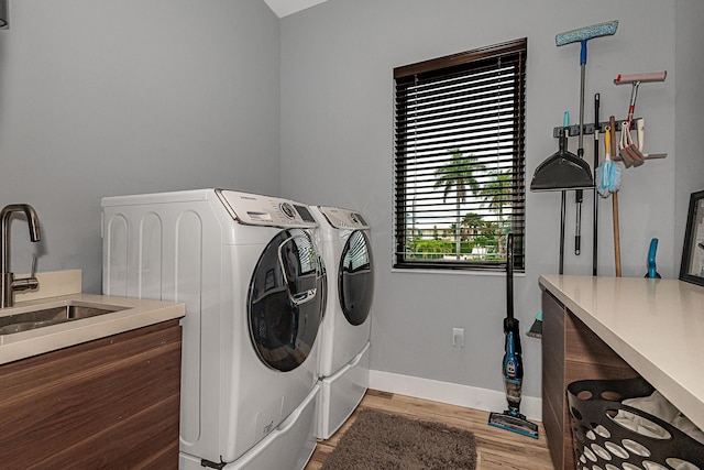 laundry room with sink, hardwood / wood-style flooring, and washer and clothes dryer