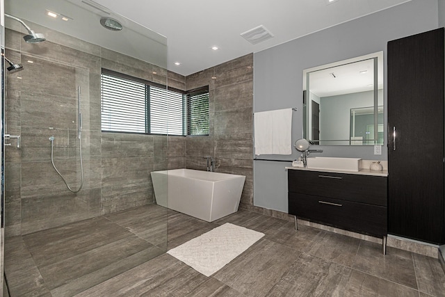 bathroom featuring vanity, tile walls, and separate shower and tub