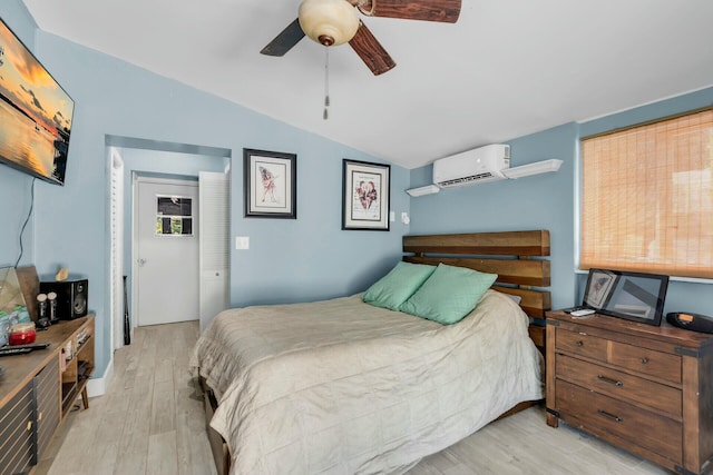 bedroom featuring vaulted ceiling, light wood-type flooring, ceiling fan, and a wall unit AC