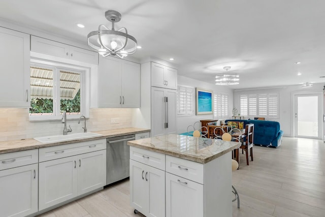 kitchen featuring sink, an inviting chandelier, decorative light fixtures, dishwasher, and white cabinets