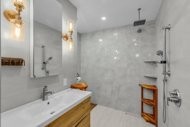 bathroom featuring vanity, tile walls, and a shower