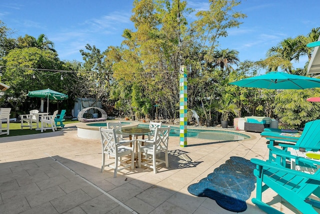 view of swimming pool featuring a hot tub, an outdoor living space, and a patio area