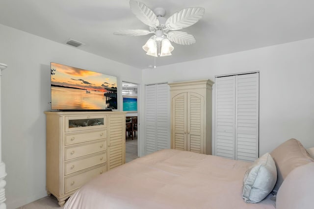 bedroom with multiple closets and ceiling fan