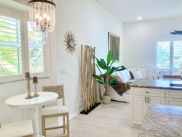 dining area with light wood finished floors, a chandelier, baseboards, and recessed lighting