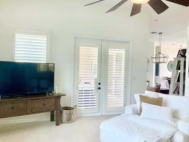 living room featuring ceiling fan with notable chandelier