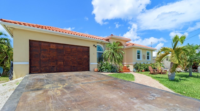 mediterranean / spanish-style home featuring driveway, stucco siding, a garage, and a tile roof