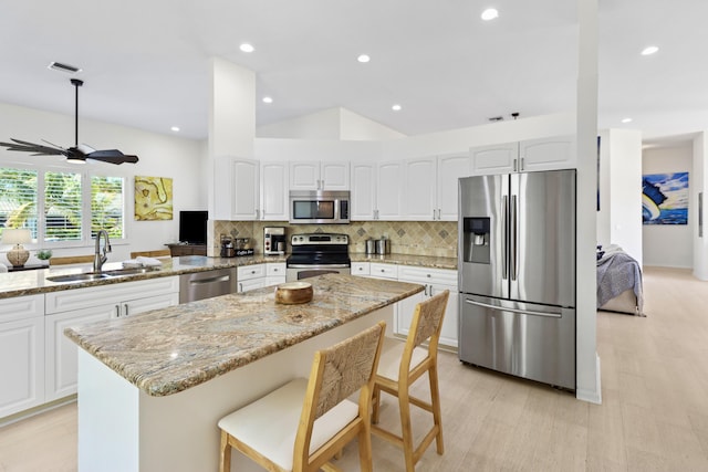 kitchen with ceiling fan, a sink, visible vents, decorative backsplash, and stainless steel appliances