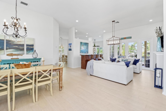 living room featuring a healthy amount of sunlight, an inviting chandelier, and visible vents