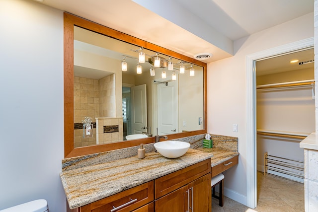 full bath with vanity, a tiled fireplace, tile patterned flooring, toilet, and visible vents