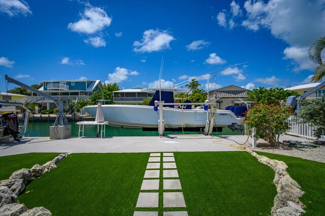 view of yard with a water view and a boat dock