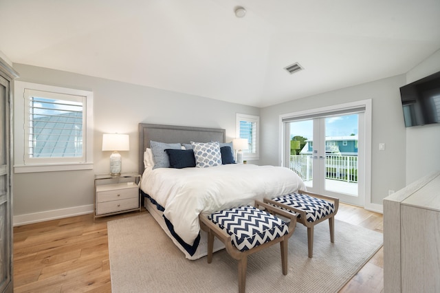 bedroom with light hardwood / wood-style flooring, access to outside, french doors, and vaulted ceiling