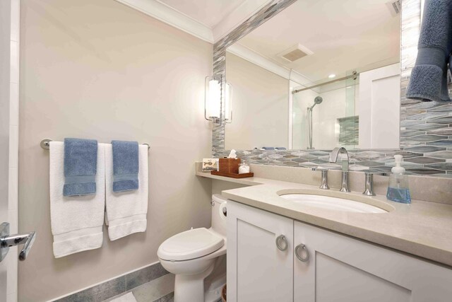 bathroom with crown molding, vanity, decorative backsplash, toilet, and walk in shower