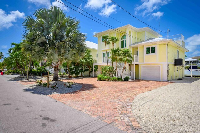 view of front of home with a garage and central air condition unit