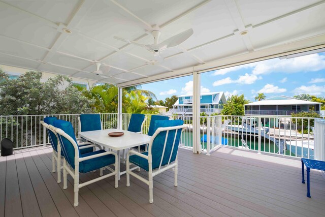 wooden terrace with ceiling fan and a water view