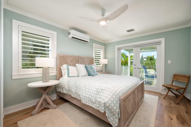 bedroom with crown molding, access to exterior, a wall unit AC, french doors, and light wood-type flooring