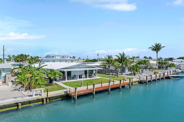 261 9th St, Key Colony, FL 33051 - view of dock featuring a water view, a patio, and a lawn