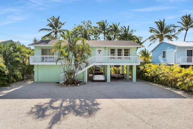878 La Paloma Rd, Key Largo, FL 33037 - coastal inspired home featuring a carport, dirt driveway, and roof with shingles