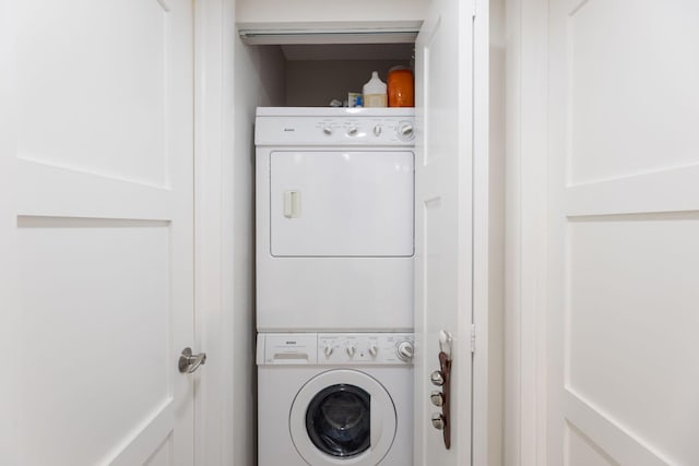 washroom featuring stacked washer and clothes dryer