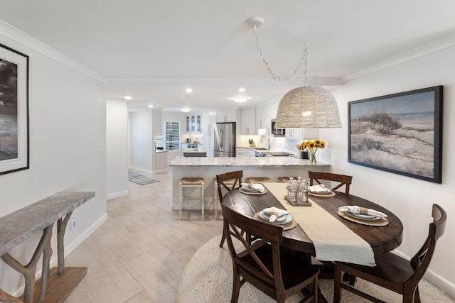 dining room featuring sink and crown molding