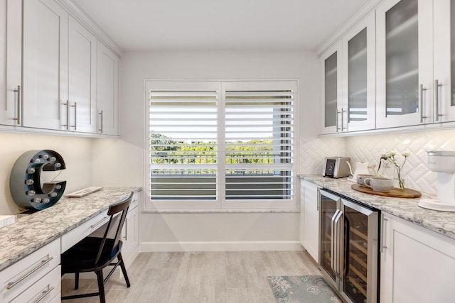 kitchen featuring wine cooler, light stone counters, decorative backsplash, and white cabinets