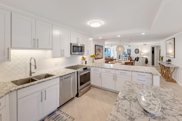 kitchen featuring white cabinetry, appliances with stainless steel finishes, sink, and light stone counters