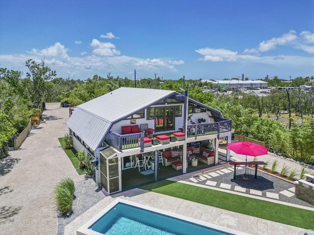 back of property featuring a balcony, an outdoor hangout area, and a patio area