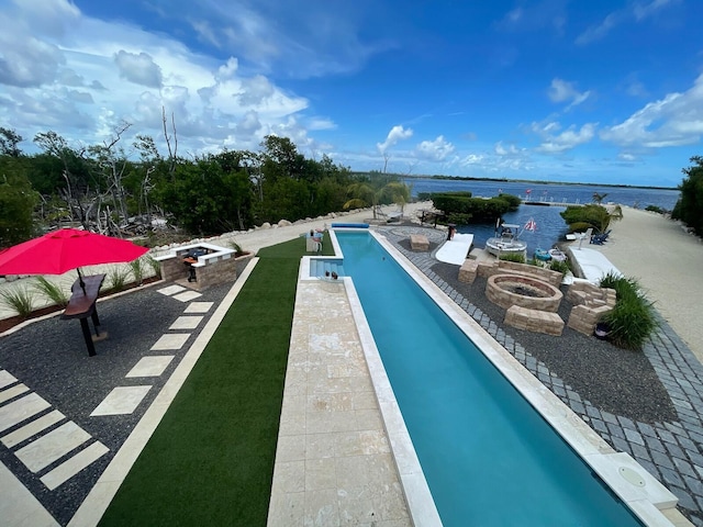 view of pool featuring a water view, an outdoor fire pit, and a patio