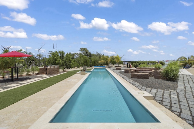 view of pool with an outdoor fire pit and a patio