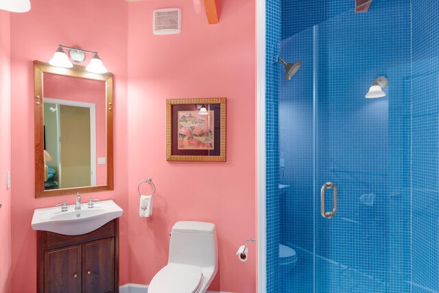 bathroom featuring vanity, toilet, and a shower with door