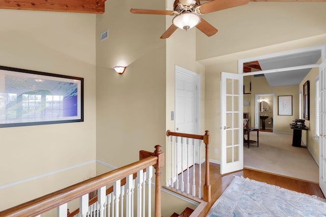 hallway with a high ceiling, light wood-type flooring, and french doors